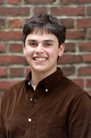 high school guy senior headshot with a brick background