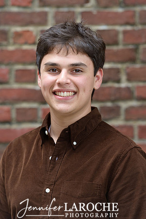 high school guy senior headshot with a brick background