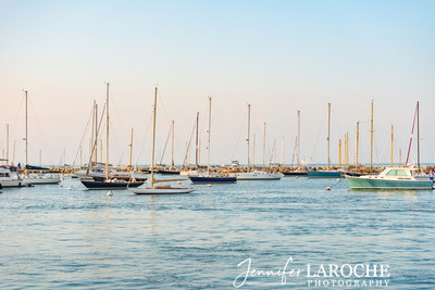 sailboats on calm ocean water at sunset